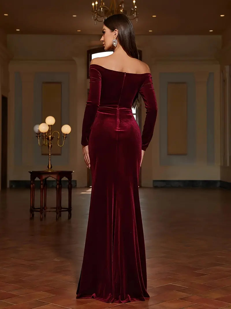 Robe longue en velours bordeaux avec épaules dénudées et fente élégante.